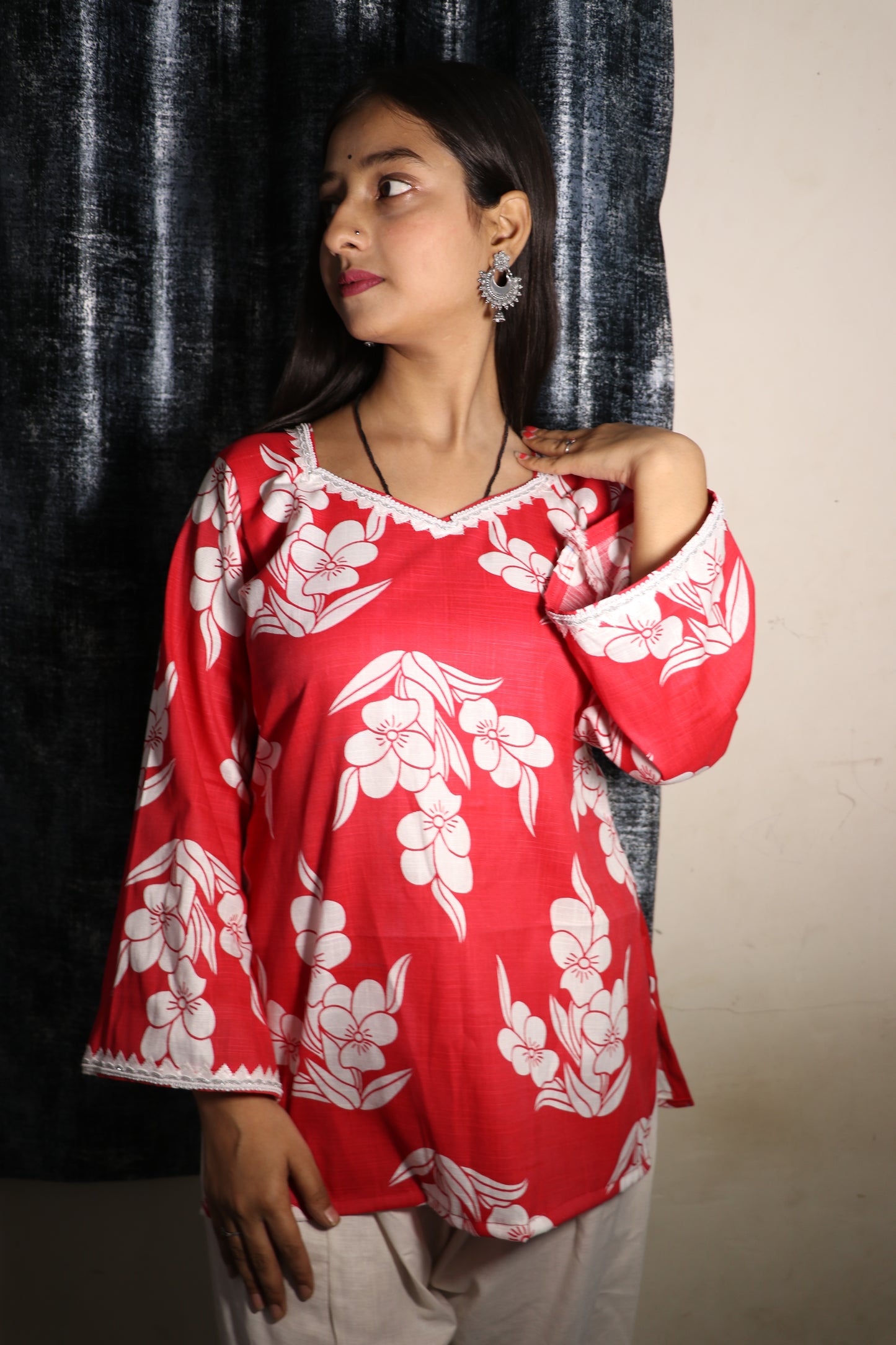 Model in Khilan Collection red floral short kurti with lace-trimmed V-neck and flared sleeves