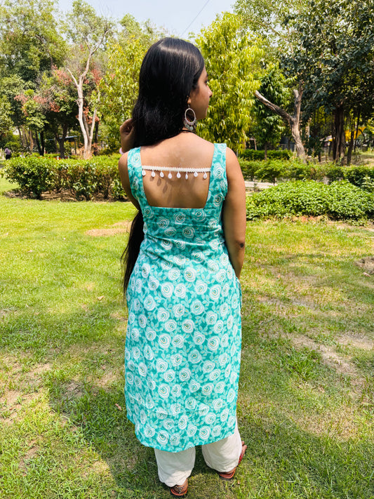 Model in Khilan Collection turquoise floral printed long cotton kurti with sleeveless design and deep back – front pose in garden